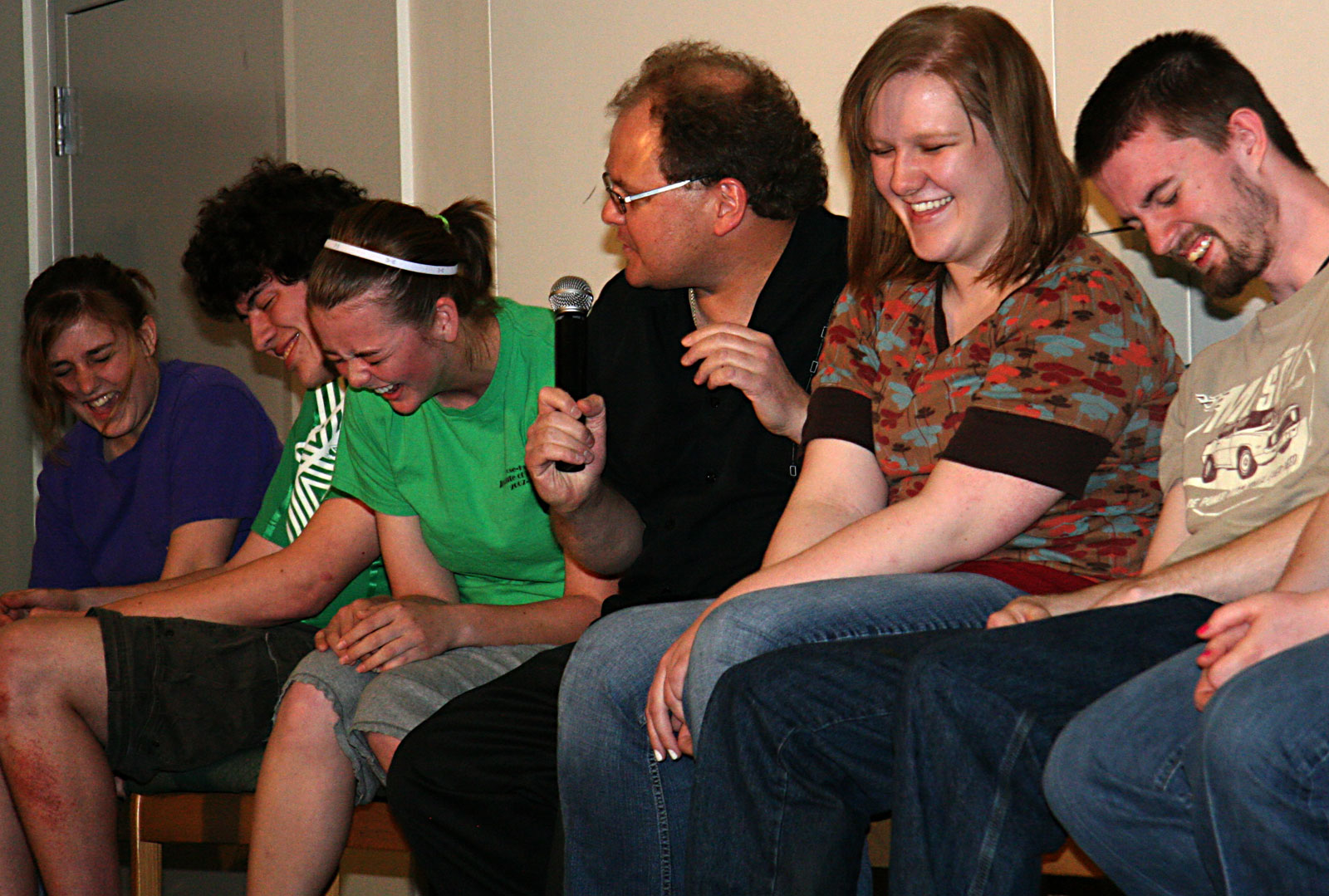hypnotist chris cady with hypnotized college students laughing on stage in hypnotism show